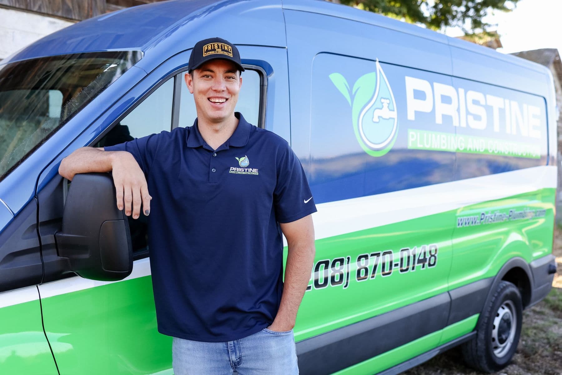 A Pristine Plumbing technician beside a company van